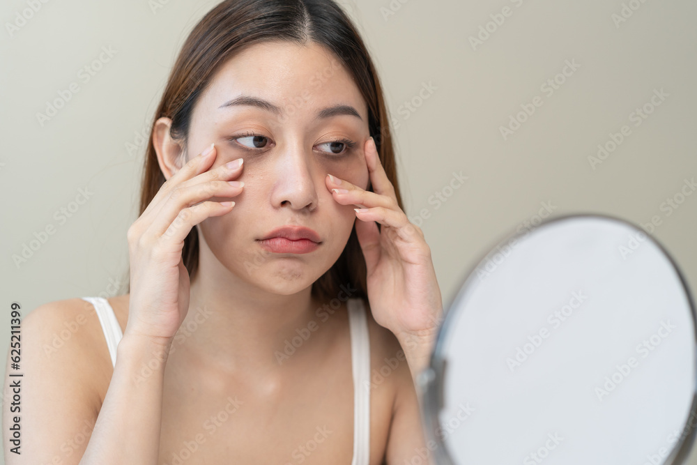 lack of sleep problem, Worried Asian young woman pointing finger at dark circles under her eyes lack of sleep problem, Worried Asian young woman pointing finger at dark circles under her eyes