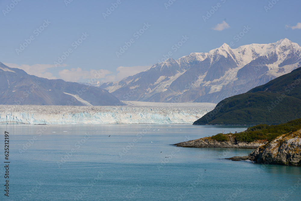 Alaskan glaciers reaching right into the ocean backed by snow capped mountains.Alaska as it should be not how it soon will be due to climate change and global warming  as the ice melts.