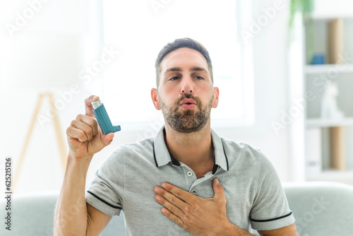 man using asthma inhaler at home