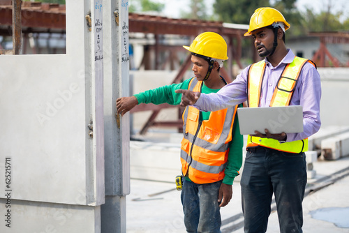 Asian indian construction architect Engineering man and senior worker in safety hardhat working on laptop computer at Prefabricated concrete factory Heavy industrial