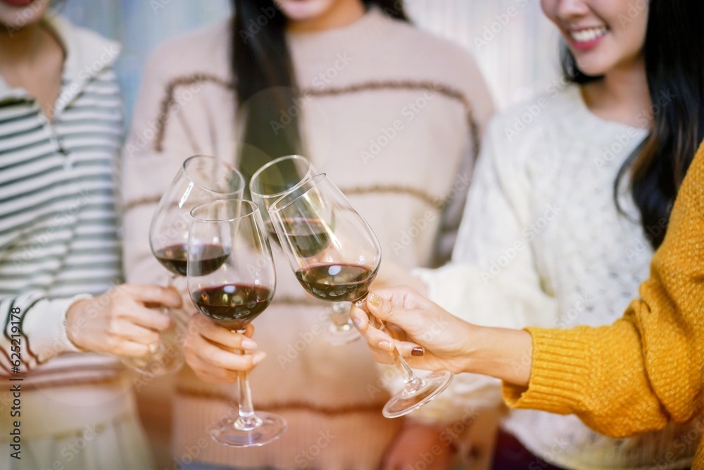 Cheerful friends enjoying home Birthday holiday party. Asian Friends cheering drinking red wine celebrating Christmas or New Year party Cheerful friends enjoying home Birthday holiday party. Asian Friends cheering drinking red wine celebrating Christmas or New Year party