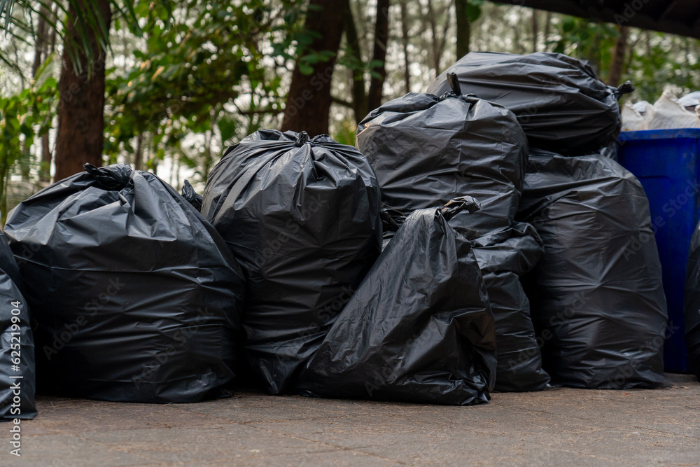 pile of disposable black garbage bags placed on ground around camping area full of trash separated wet waste and plastic for recycling, volunteer cleaning beach for protecting the environment pile of disposable black garbage bags placed on ground around camping area full of trash separated wet waste and plastic for recycling, volunteer cleaning beach for protecting the environment