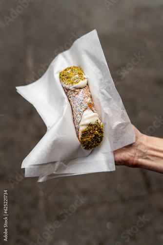 A fresh Sicilian cannoli filled with ricotta cheese and pistachio nuts