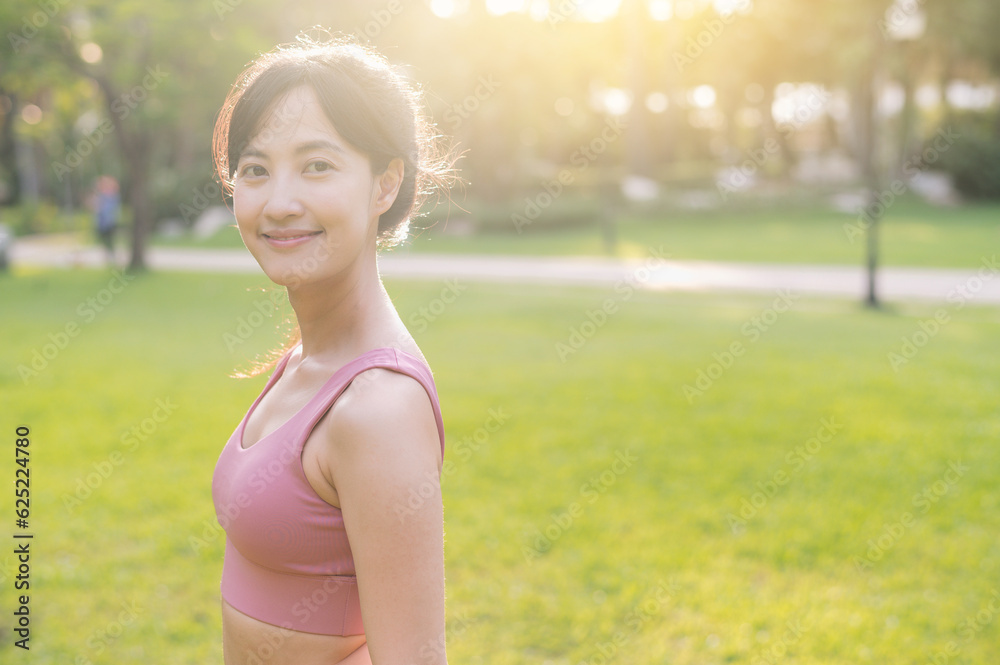 Capture the happiness and wellness living of a beautiful young Asian woman in her 30s, smiling and looking at the camera in a park at sunset. Embrace the concept of wellness living. Capture the happiness and wellness living of a beautiful young Asian woman in her 30s, smiling and looking at the camera in a park at sunset. Embrace the concept of wellness living.
