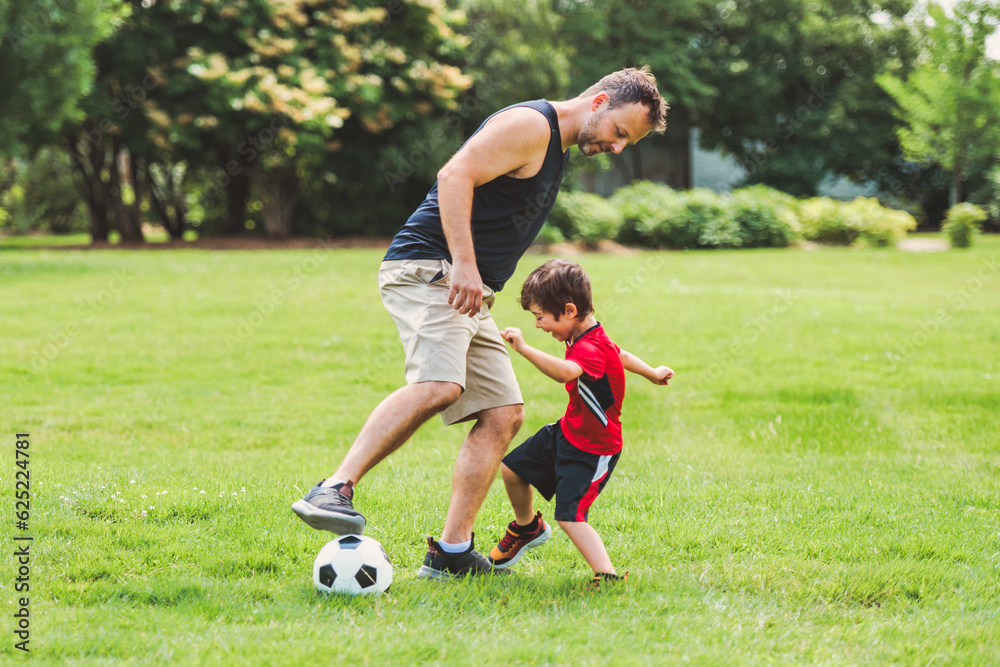 Young soccer player having fun on a field with his father Young soccer player having fun on a field with his father