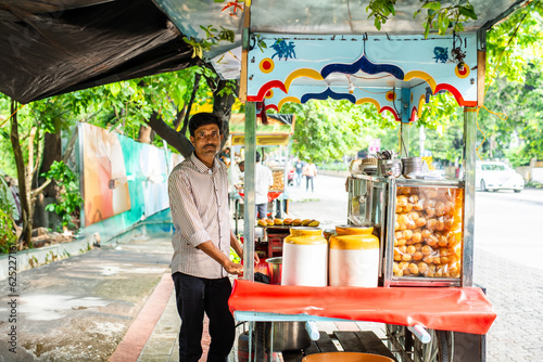 Photography panipuri shop -happy young male Indian roadside vendor selling golgappe