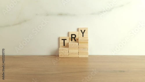 Word try made from wooden blocks. Purpose and movement to success despite obstacles