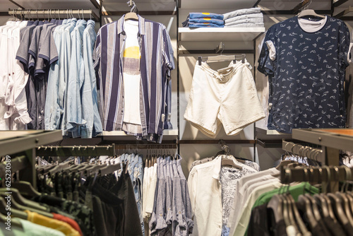 Men's summer casual clothes on hangers in the store. Style, fashion and comfort. © Анна Демидова