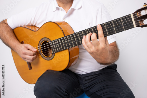 close-up of adult man playing guitar isolated over white background.