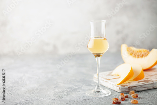Homemade sweet alcoholic liqueur with melon in glass.