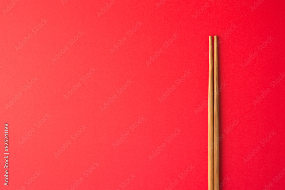 Wooden Chinese chopstick on red background copy space. Concept of abstract China economy GDP growth falls short and chinese food restaurant. China is world 's largest economy by nominal GDP behind USA Wooden Chinese chopstick on red background copy space. Concept of abstract China economy GDP growth falls short and chinese food restaurant. China is world 's largest economy by nominal GDP behind USA