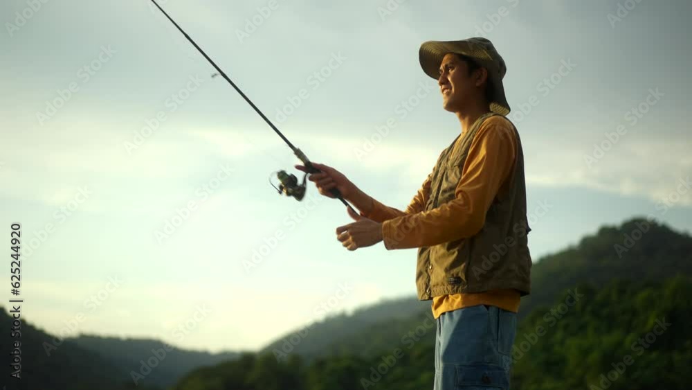 Close-up shot enjoy moment of Handsome man fishing as a leisure activity during his vacation at the lake on sunset. Relax and hobby concept. Close-up shot enjoy moment of Handsome man fishing as a leisure activity during his vacation at the lake on sunset. Relax and hobby concept.