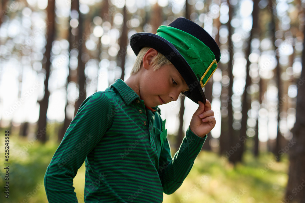 Cute little leprechaun boy posing in a high hat. Portrait of a adorable white kid dressed in green for a Saint Patricks Day festival Cute little leprechaun boy posing in a high hat. Portrait of a adorable white kid dressed in green for a Saint Patricks Day festival