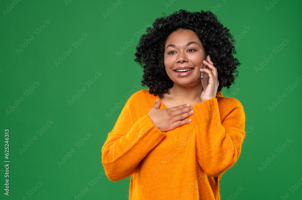 Dark-haired woman in orange talking on the phone Dark-haired woman in orange talking on the phone