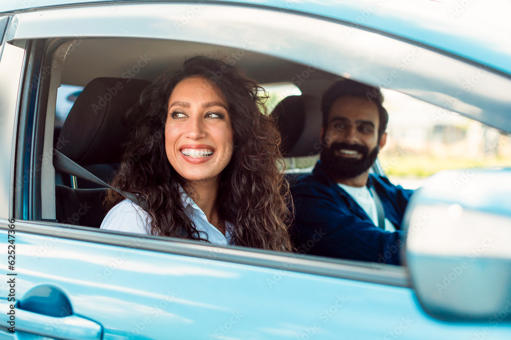 © Prostock-studio - Enjoy family journey. Arab man driving car, focus on smiling lady sitting in auto on passenger seat with open window
