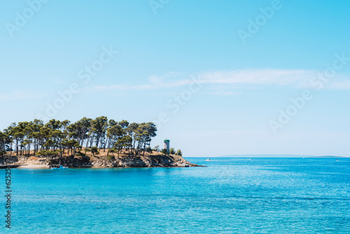 Small rocky island with lighthouse on the Rajska beach on the Rab island in Croatia