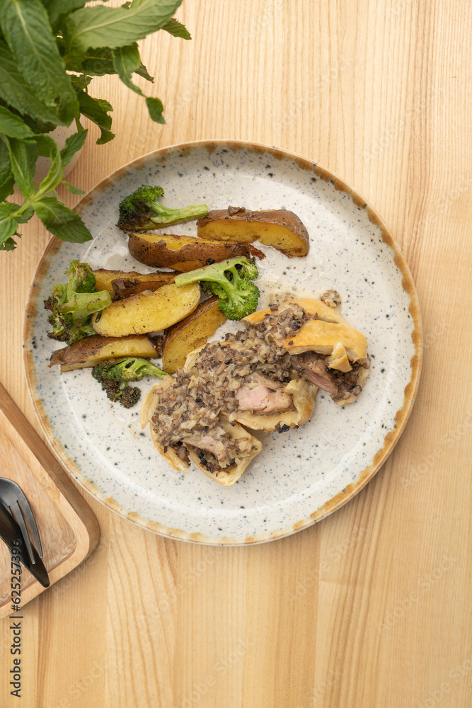 Baked meat in dough with potatoes and broccoli on wooden table top view, flat lay. Baked meat in dough with potatoes and broccoli on wooden table top view, flat lay.