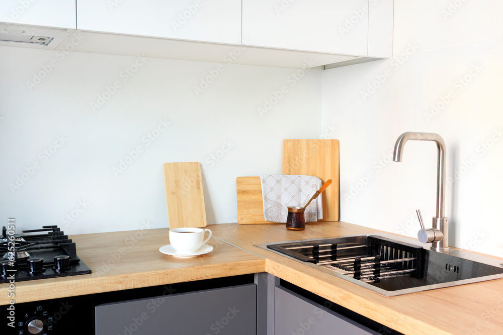 The design of a modern kitchen in the style of vloft with gray and white facades and wooden countertops