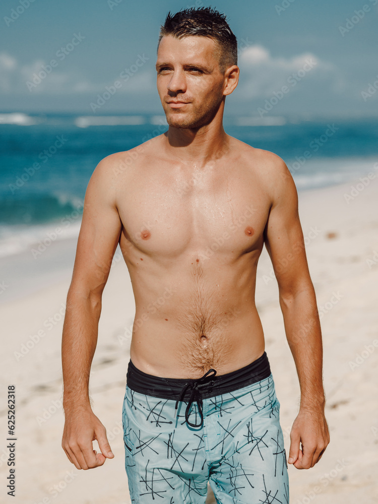 Handsome slim man enjoying day on the summer beach.