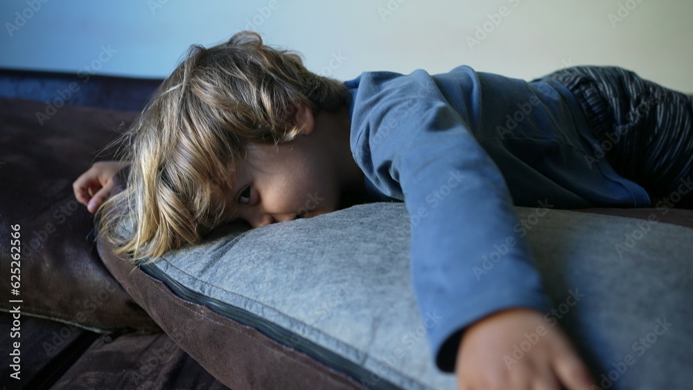 Child lying on sofa playing at home climbing couch Child lying on sofa playing at home climbing couch