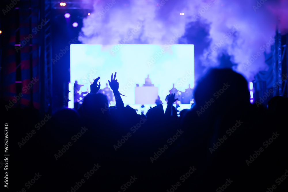 Abstract photo of crowd at concert and blurred stage lights.