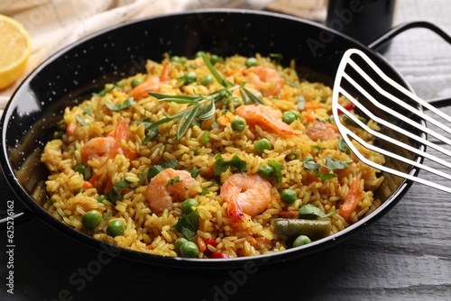 Tasty rice with shrimps and vegetables in frying pan on grey table, closeup