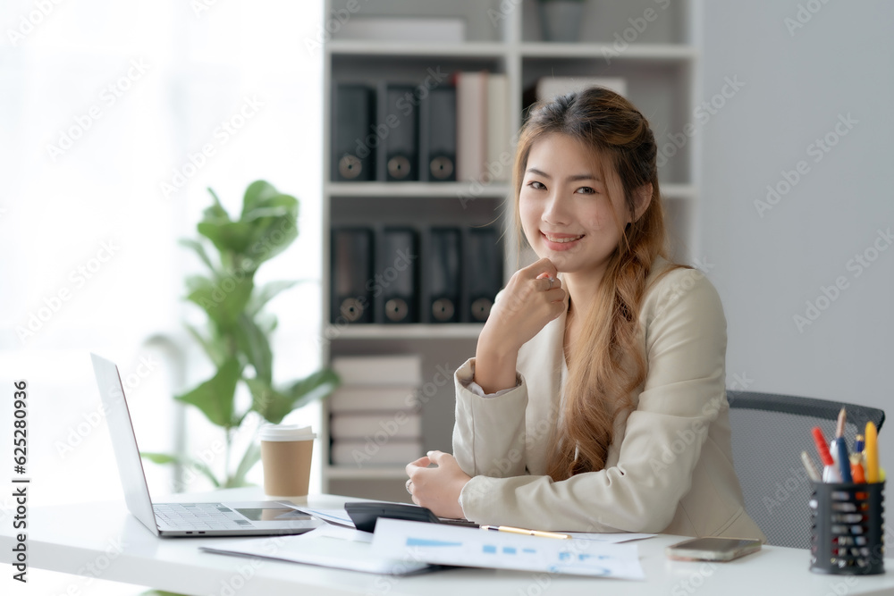 Confident Asian Businesswoman Sitting in Modern Office With Laptop Computer. Confident Asian Businesswoman Sitting in Modern Office With Laptop Computer.