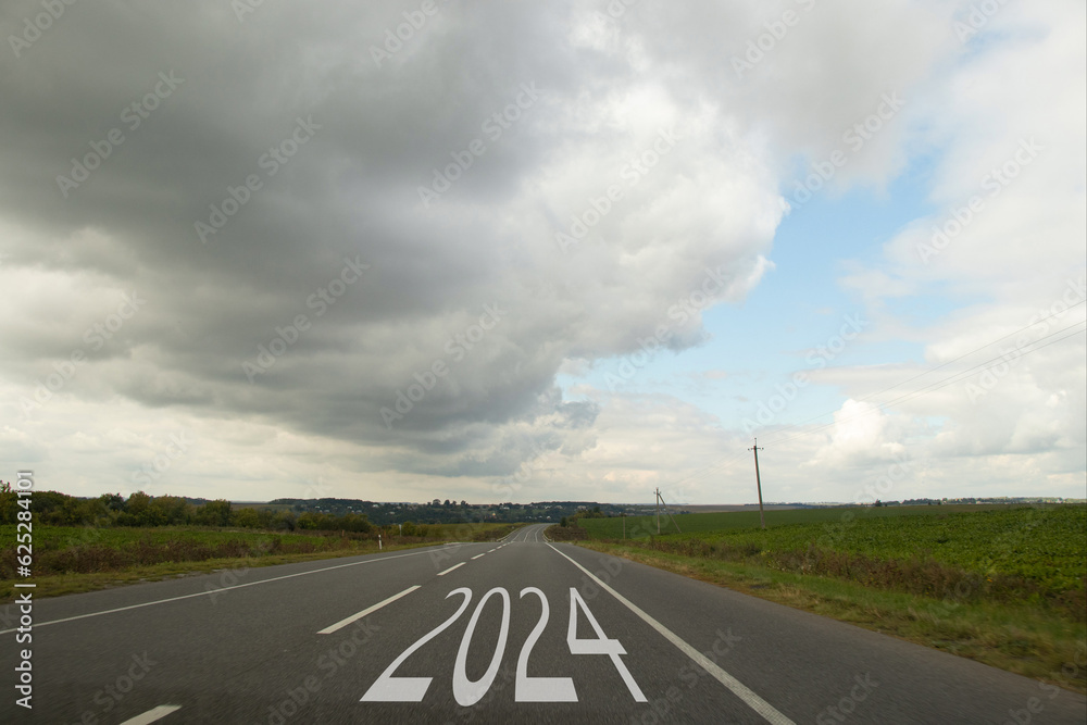 Long asphalt road in Ukraine and 2024 is written on the asphalt, new year Long asphalt road in Ukraine and 2024 is written on the asphalt, new year