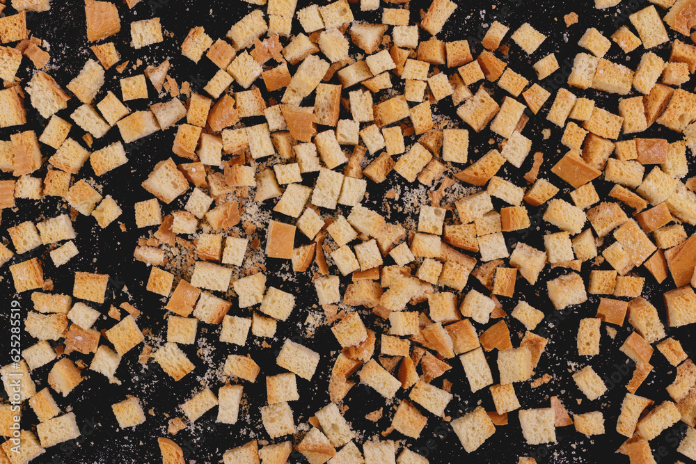 Pieces of roasted white bread on a dark background. Close-up of delicious croutons. Top view Pieces of roasted white bread on a dark background. Close-up of delicious croutons. Top view