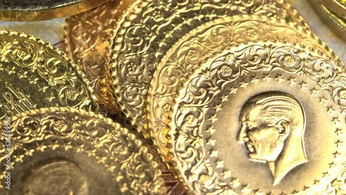 Gold coins on the Turkish bill background, pan. Gold treasure heap camera panning. Macro view of a quarter gold Turkish coins. 
