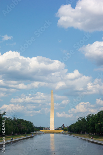 Washington Monument in Washington DC with across from the reflecting pond. Pictures taken on a sunny summer day with a nice amount of clouds evenly spread out in the sky.
