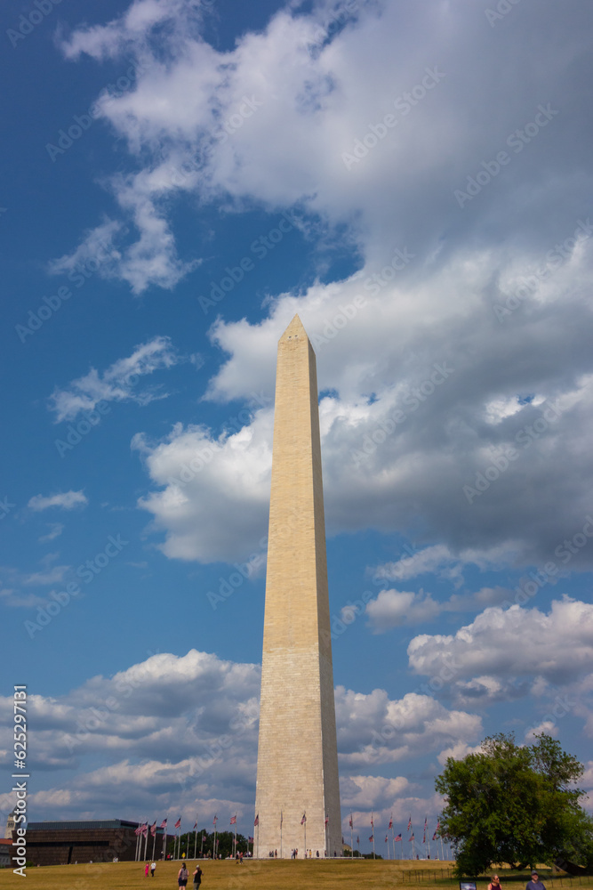 Washington Monument in Washington DC with across from the reflecting pond. Pictures taken  on a sunny summer day with a nice amount of clouds evenly spread out in the sky.