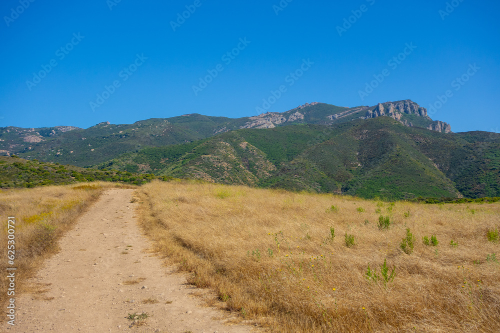 Hiking Views of golden grass, green bushes, and the Santa Monica Mountians, in Ventura County during the summer. Hiking Views of golden grass, green bushes, and the Santa Monica Mountians, in Ventura County during the summer.
