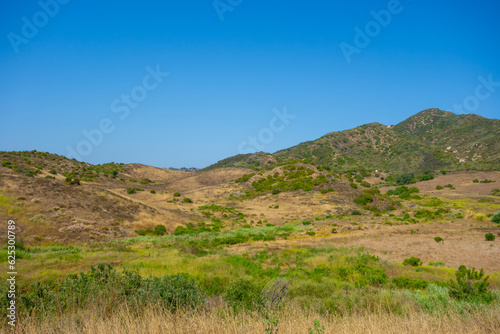 Fototapeta Naklejka Na Ścianę i Meble -  Hiking Views of golden grass, green bushes, and the Santa Monica Mountians, in Ventura County during the summer.