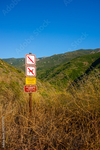 Hiking Views of golden grass, green bushes, and the Santa Monica Mountians, in Ventura County during the summer.