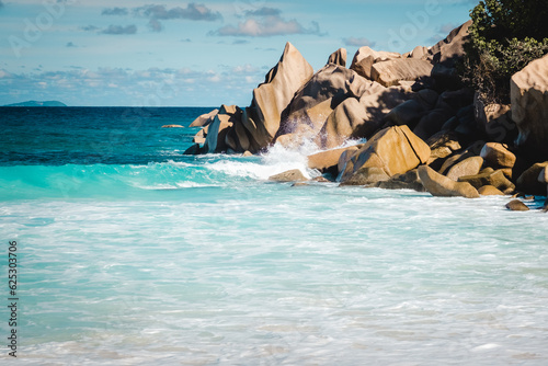 Big granite rocks on the Grand Anse beach. La Digue island, Seychelles. Tropical landscape with sunny sky.