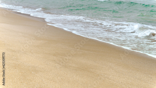 Slow motion of calm sea waves rolling on sandy beach on cold cloudy day. End of seasonal tourism, travel in winter.