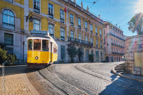 Famous vintage yellow tram 28 in the narrow streets of Alfama district in Lisbon, Portugal - symbol of Lisbon, famous popular travel destination and tourist attraction