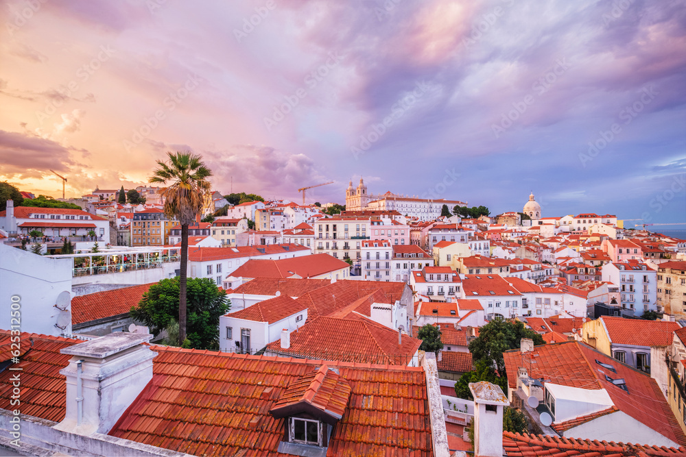 Obraz premium View of Lisbon famous view from Miradouro de Santa Luzia tourist viewpoint over Alfama old city district on sunset with dramatic overcast sky. Lisbon, Portugal.