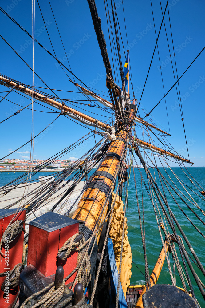 Obraz premium Bowspirit of old wooden sail ship with a lot of gear cordage rope