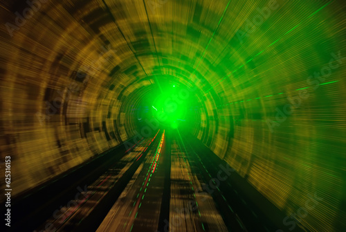 A frontal view from a subway driving in a green illuminated tunnel 