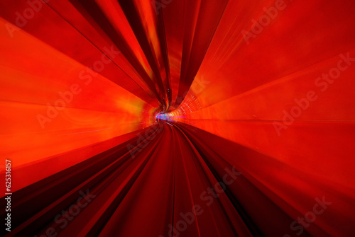 A frontal view from a subway driving in a red illuminated tunnel 
