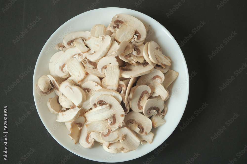 Fresh champignons mushroom in a white bowl on table Fresh champignons mushroom in a white bowl on table