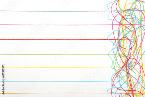 Multicolored tangled knitting threads on a white background