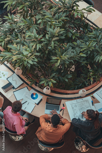 Group of coworkers working together and talking at modern office. Workplace and cooperation concept