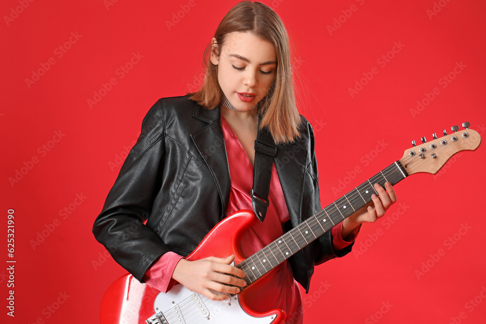 Young woman playing guitar on red background Young woman playing guitar on red background