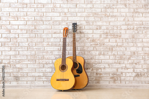 Two guitars near brick wall © Pixel-Shot