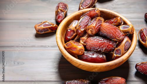 Dates or dattes palm fruit in wooden bowl is snack healthy.