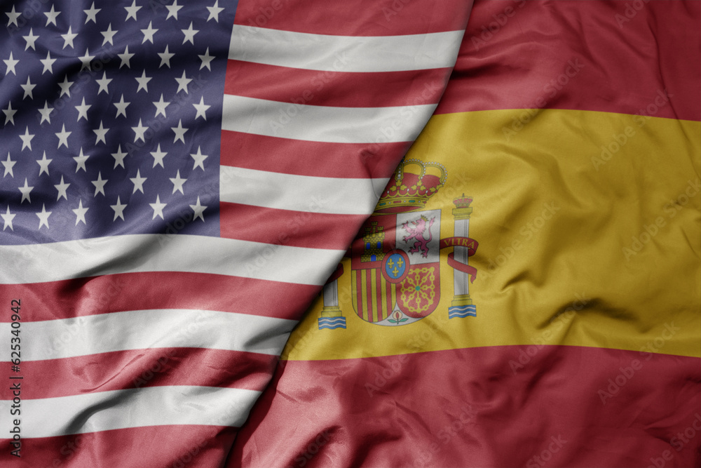 Obraz premium big waving colorful flag of united states of america and national flag of spain .