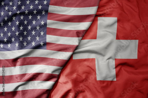 big waving colorful flag of united states of america and national flag of switzerland .